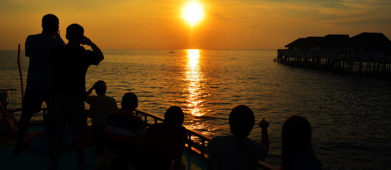 Tourists Watching The Sun Set In The Maldives
