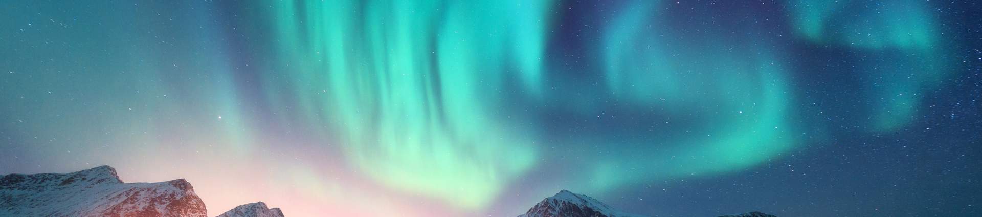 Aurora Borealis Over The Sea, Snowy Mountains And City Lights At Night