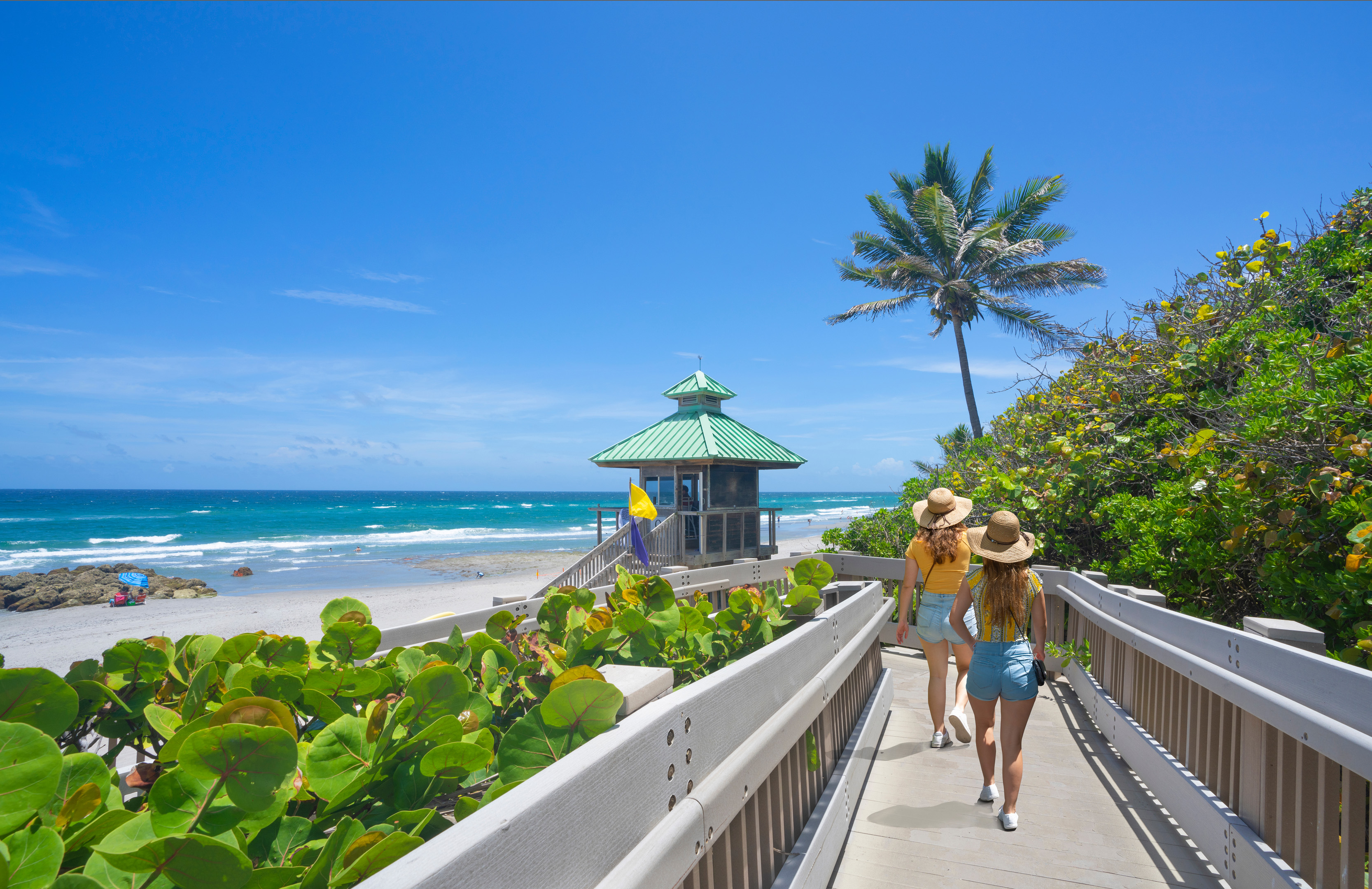 Women Walking On Boardwalk To Florida Beach