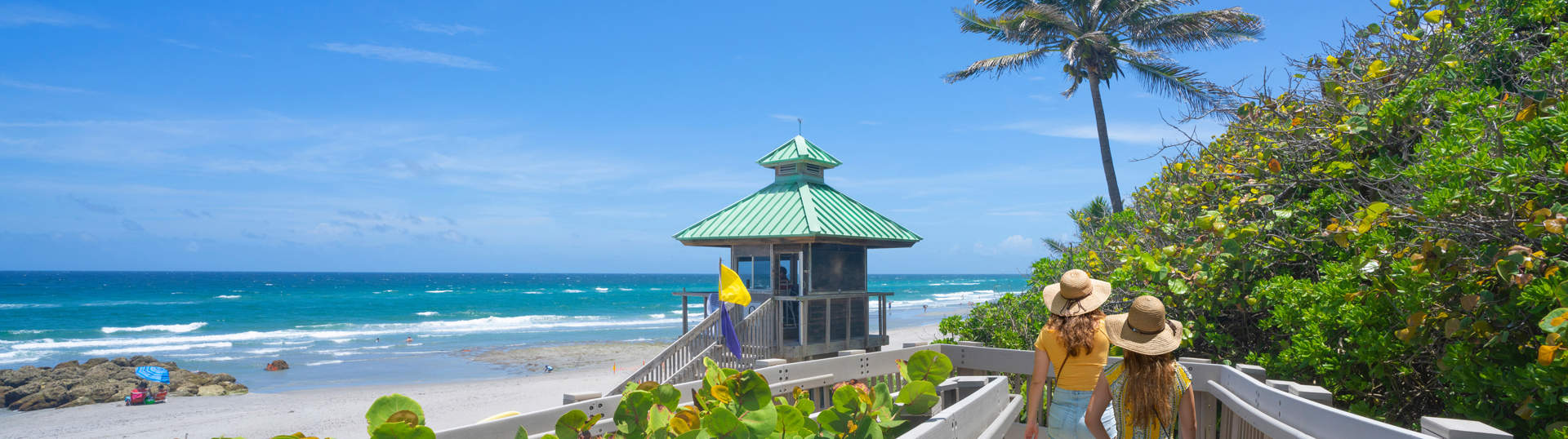 Women Walking On Boardwalk To Florida Beach