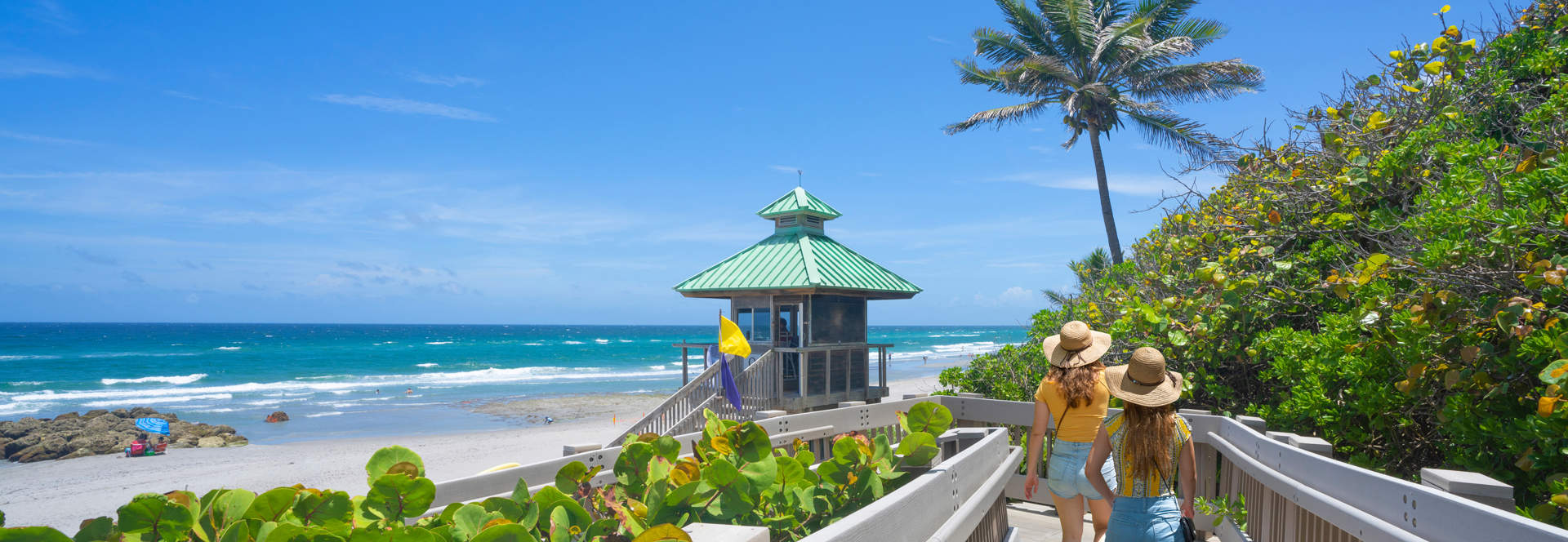 Women Walking On Boardwalk To Florida Beach