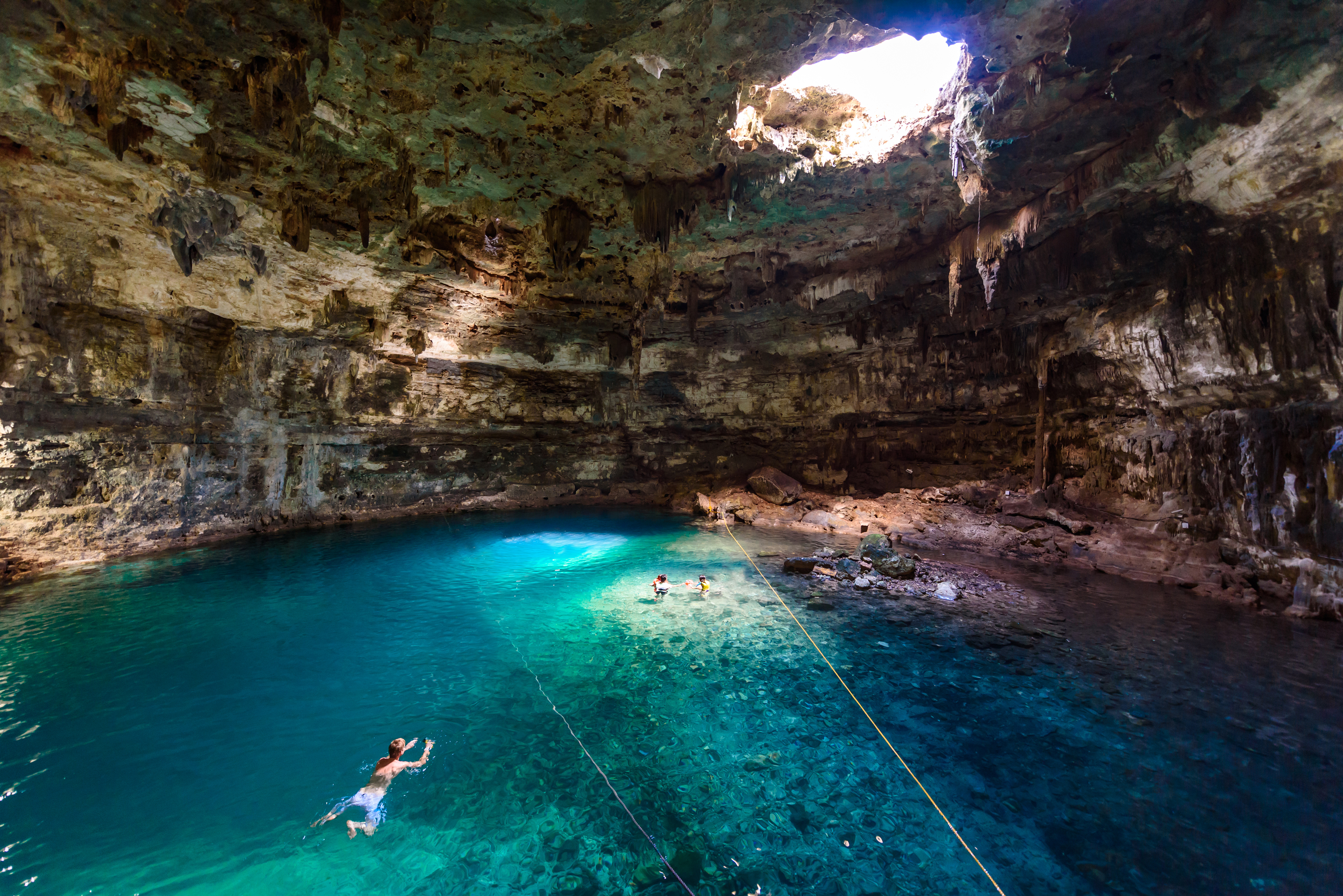 Tourists Swimming In Cenote Mexico