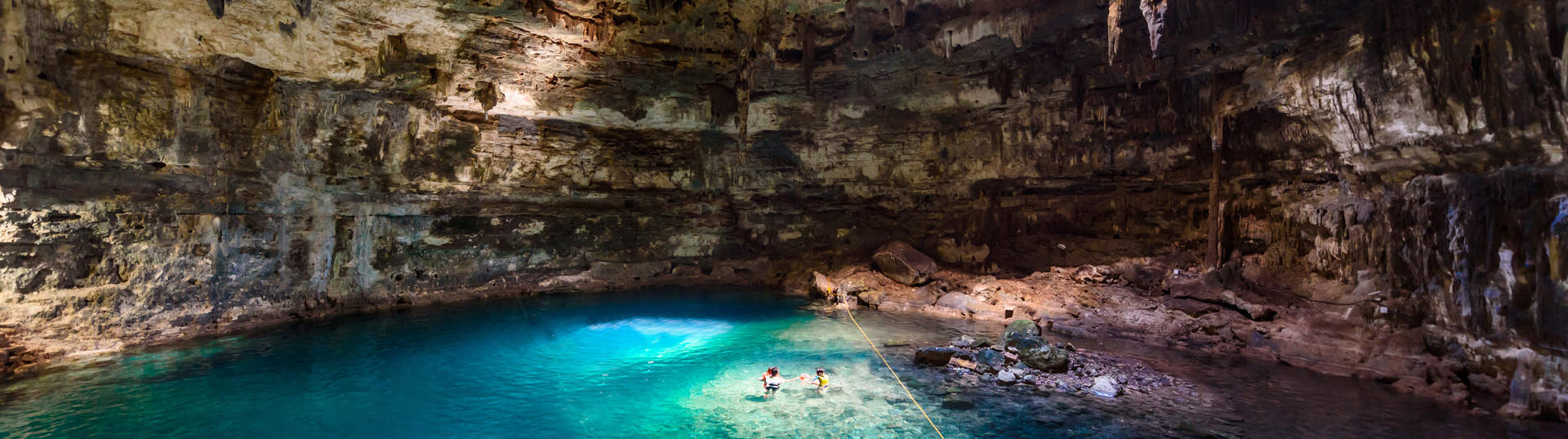 Tourists Swimming In Cenote Mexico