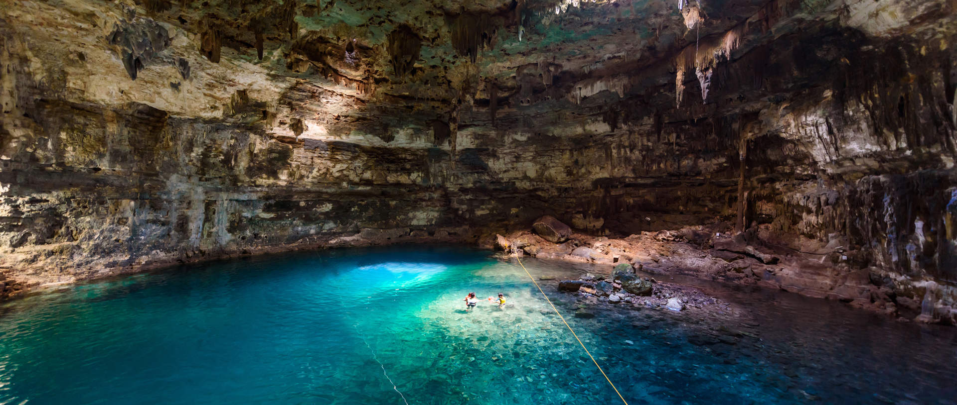 Tourists Swimming In Cenote Mexico